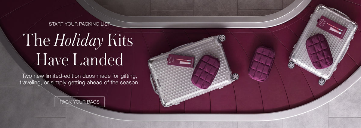 Website banner showing two makeup cases on a burgundy background with the text The Holiday Kits Have Landed and a Pack Your Bags button