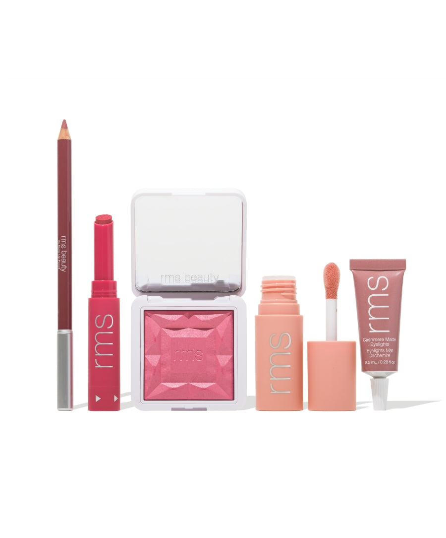 Collection of RMS Beauty makeup products in shades of pink and peach including pencil, lipstick, blush, liquid color, and lip treatment labeled Color Capsule: The Raspberry Wine Sorbet Edit with natural ingredients and clean beauty focus