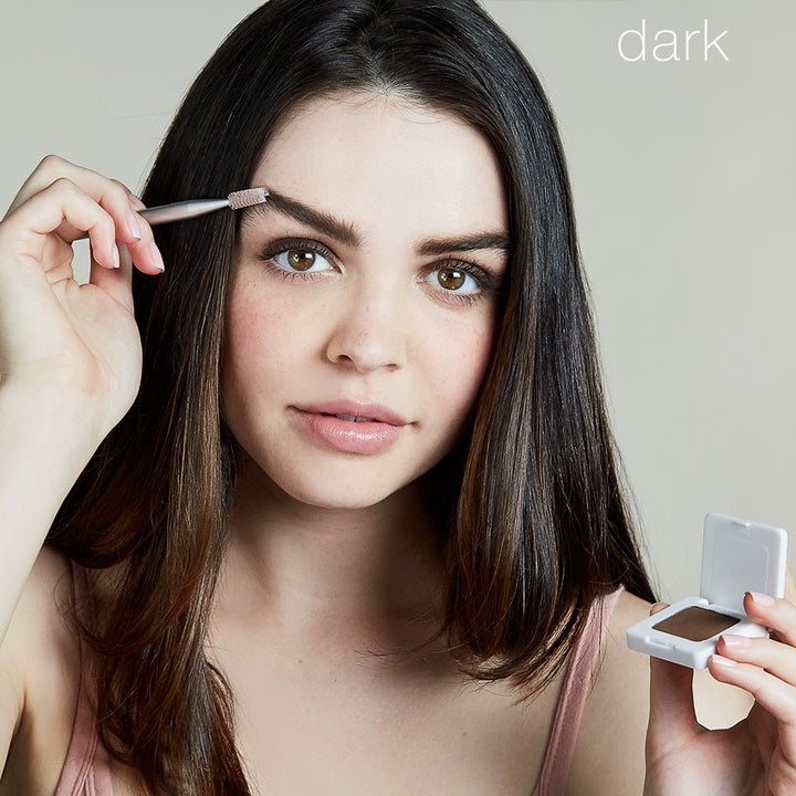 Model using Back2Brow Brush on right brow, holding Back2Brow Powder in left hand.
