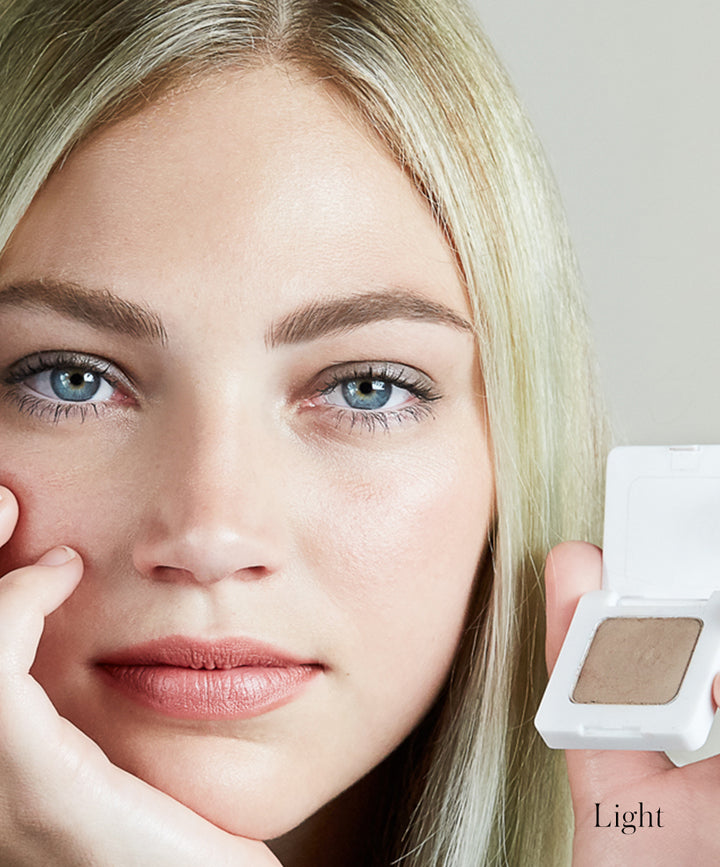 Close-up of model wearing Back2Brow Powder in shade Light. Holding Back2Brow Powder product in shade Light ideal for blonde/light brown hair
